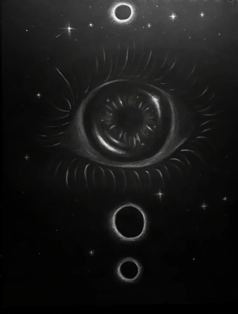 Dibujo a carboncillo blanco sobre papel negro de un ojo grande rodeado de pestañas, con anillos en eclipse arriba y abajo sobre un campo de estrellas