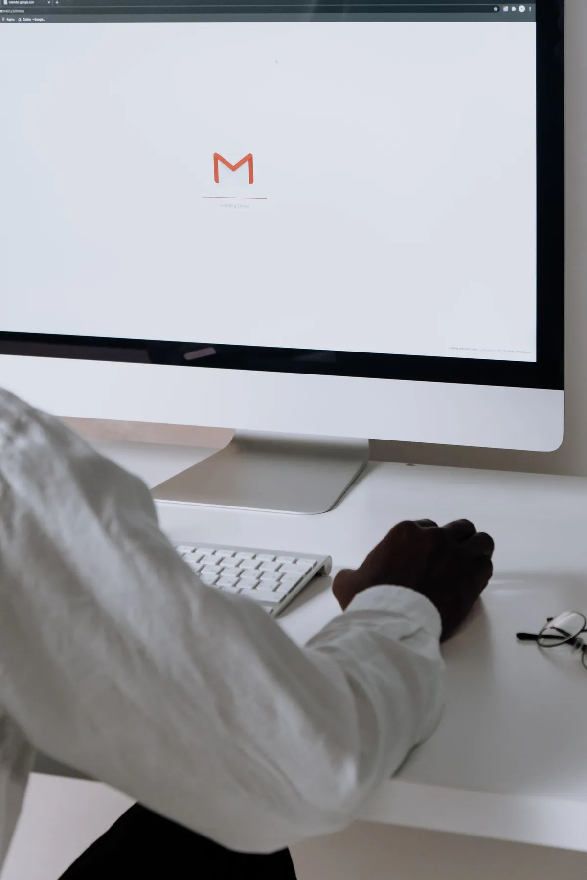 A professional reviewing incoming email messages on a desktop computer in a bright office, representing contact form submissions arriving in an inbox.